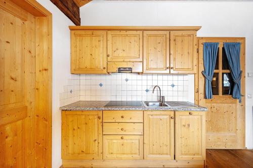 a kitchen with wooden cabinets and a sink at Plazores in San Vigilio Di Marebbe