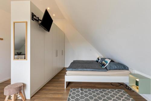 a bedroom with a bed and a tv on the wall at Fewo Parkside S5 - 8Min Legoland in Günzburg