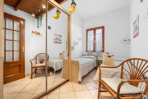 a bedroom with a bed and a chair and a mirror at Sole Mare di Barbara in Chia
