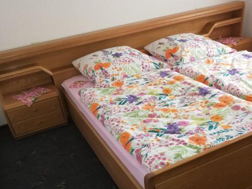 a bed with a floral comforter and pillows on it at Ferienwohnung Josefa Ganter 80qm in Ühlingen-Birkendorf