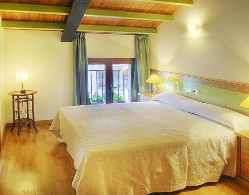 a bedroom with a large white bed and a window at Apartamento ll in Iráizoz