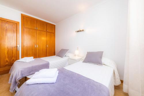 two beds in a room with wooden cabinets at Es Pujol in Alcudia