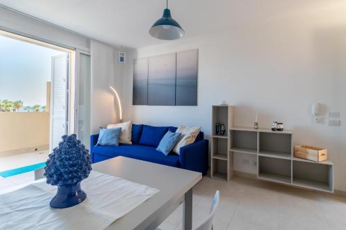 a living room with a blue couch and a table at Brezzadisudest in Marina di Ragusa