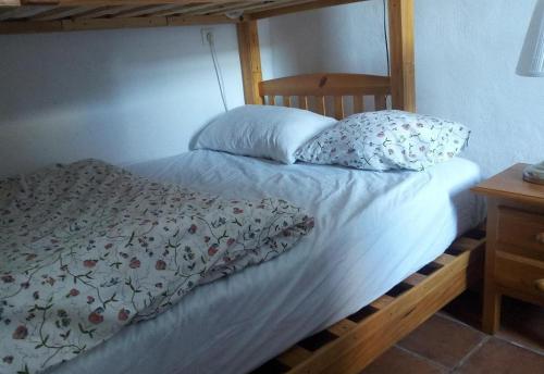 a bed with a white bedspread and pillows on it at Townhouse Almunecar Old Town in Almuñécar