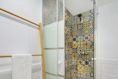 a bathroom with a shower with mosaic tiles at Adega Peróla in Cais do Galego