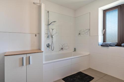 a white bathroom with a tub and a sink at Gatscherhof Apt Abendrot in Luson
