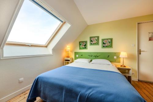 a bedroom with a large bed with a large window at La Demeure Océane in Portsall