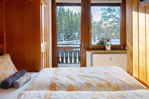 a bedroom with a bed and a large window at Oskar im Bärenhüsli in Titisee-Neustadt