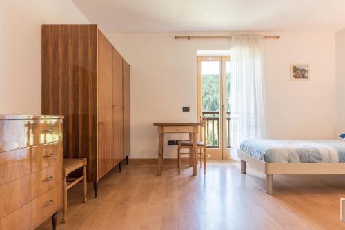 a bedroom with a bed and a dresser and a desk at Baita Serpillo in Palù del Fersina