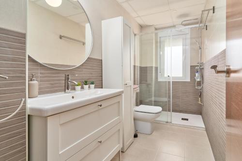 a bathroom with a sink and a toilet and a mirror at Recreo 10 in Torrox