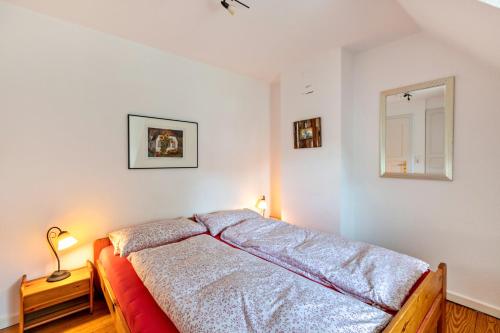 a bedroom with a bed and a mirror on the wall at Skriiwers Hüüs in Alkersum