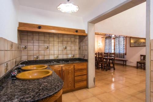 a kitchen with two sinks on a counter and a table at Es Caulls in Llubí