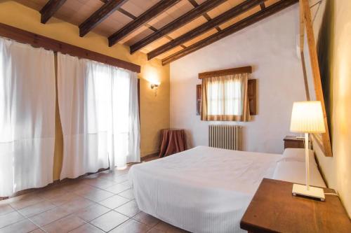 a bedroom with a white bed and a window at Es Caulls in Llubí