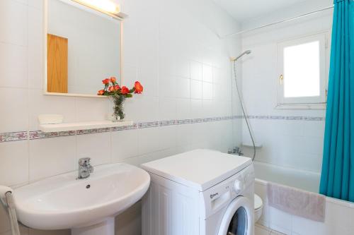 a white bathroom with a sink and a washing machine at White Sands Maluz in Arenal d'en Castell