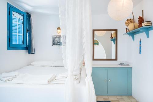 a bedroom with a bed with white curtains at Beachfront Lampis Dolphin 4 in Skala