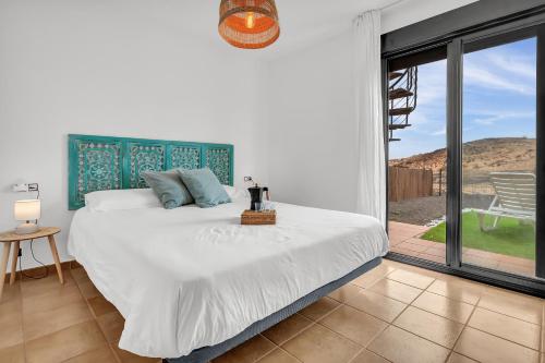 a bedroom with a large bed and a balcony at Villa Manuela in Lajares