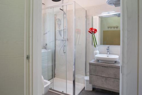 a bathroom with a glass shower and a sink at Villa Stanga in Sedico