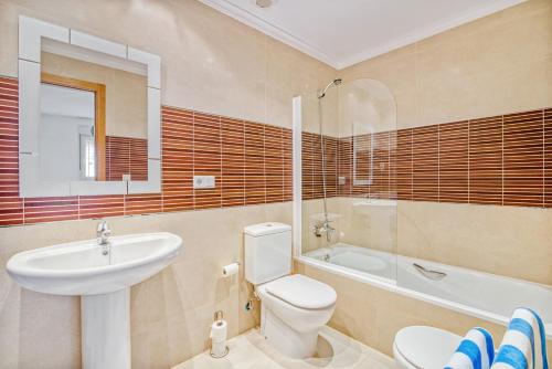 a bathroom with a toilet and a sink and a tub at Amanda in Jávea