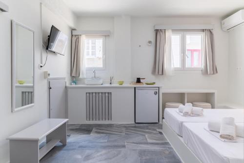 a white room with two beds and a sink at A Tinian Room 1 in Tinos
