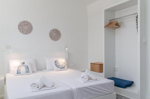 a white bedroom with two white pillows on a bed at A Tinian Room 1 in Tinos