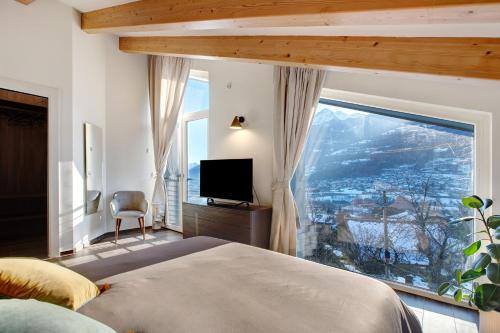 a bedroom with a bed and a large window at La Maison du Renard in Sarre