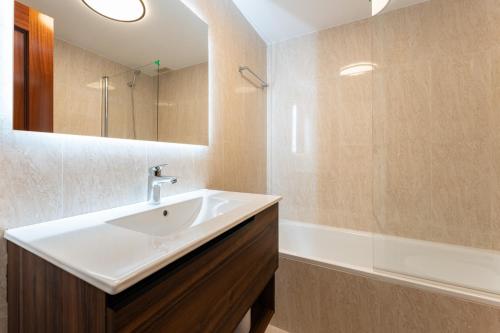 ein Badezimmer mit einem weißen Waschbecken und einer Badewanne in der Unterkunft Oasis Mijas Centro in Mijas