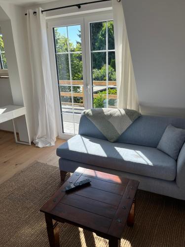 a living room with a blue couch and a coffee table at Landhausloft in Bermatingen