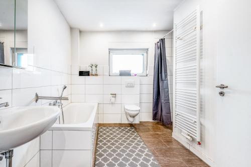 a white bathroom with a sink and a toilet at Haus Primavera in Bad Bentheim