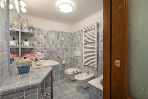 a blue tiled bathroom with a toilet and a sink at Da Manu - Blavy Nus in Blavy