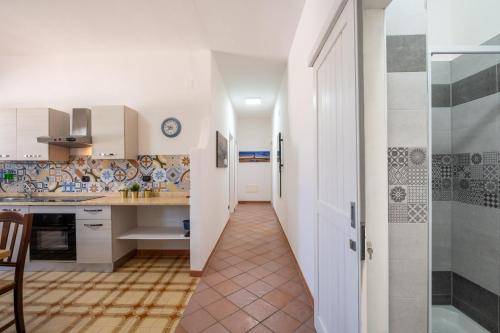 a kitchen with white cabinets and a tile floor at Villa Gaudì - Sagrada in Sant'Isidoro