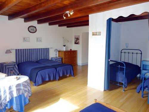 a bedroom with two beds and a wooden floor at Domaine de Chante-Oiseau - 34 pers in Theil-Rabier