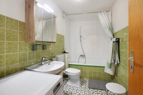 a bathroom with a toilet and a tub and a sink at Ferienwohnung Rehm in Bad Säckingen