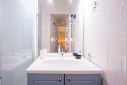 a white bathroom with a sink and a mirror at Résidence Les Bergers 71 in Valloire