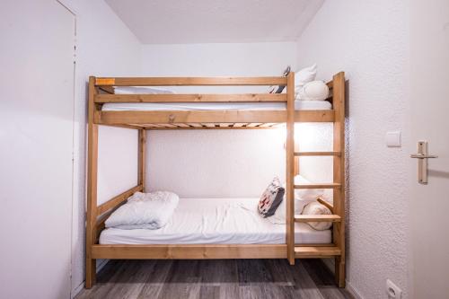 a bunk bed in a small room with a ladder at Résidence Les Bergers 71 in Valloire