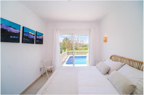 a white living room with a couch and a pool at Villa Del Sol - Solo Familias 1819 in Jávea