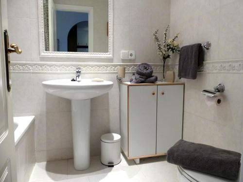 a white bathroom with a sink and a mirror at Appartement Tesoro del Mar in Torrox Costa