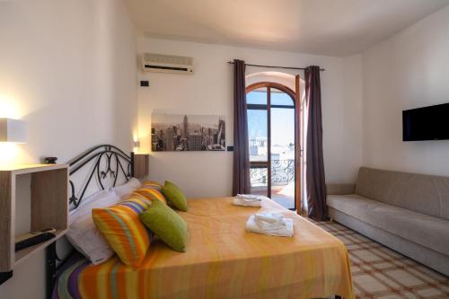 a room with a bed with a couch and a window at Villa Gaudì - Sagrada in Sant'Isidoro