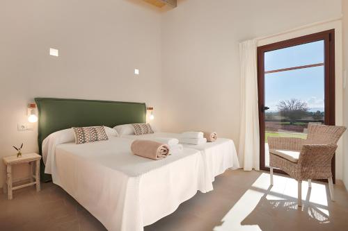 a bedroom with a bed with white sheets and a window at Son Rossinyol Nou - Ses Figueretes in Islas Baleares