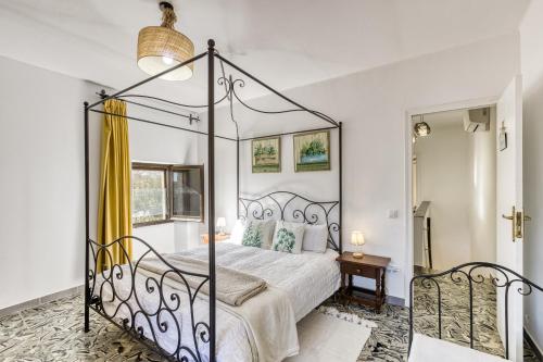 a bedroom with a canopy bed and a mirror at El Figuerar in Palamós
