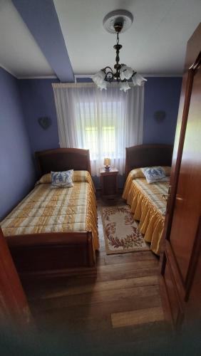 a bedroom with two beds and a window at Finca El Carbayal in El Campo