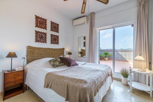 a bedroom with a bed and a large window at Penthouse Victoria in Fuengirola