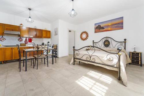 a bedroom with a bed and a table and a kitchen at Casa Vacanza Da Gabry in Perdaxius