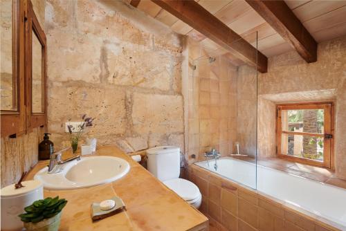 a bathroom with a sink and a toilet and a tub at Son Garreta in El Palmer