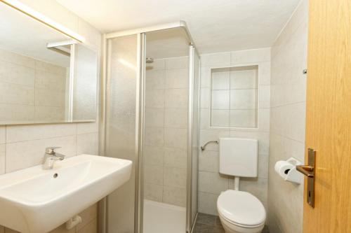 a white bathroom with a sink and a toilet at Oberhöher Apt Talblick in San Pietro