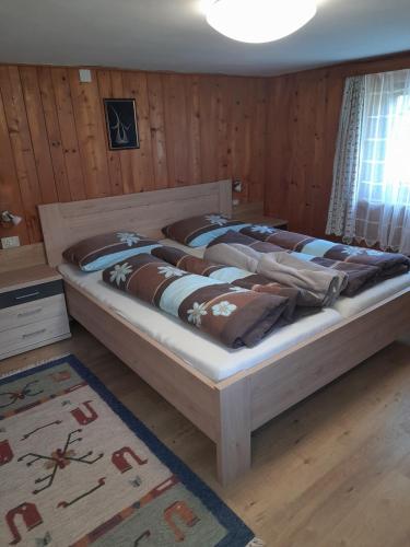 two beds in a room with wooden walls at Oberhöher Apt Talblick in San Pietro