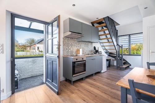 a kitchen with a stove top oven next to a staircase at Gîte Ty Berniques in Pléneuf-Val-André
