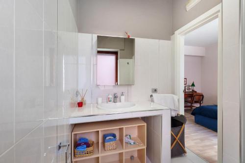 a white bathroom with a sink and a mirror at Casa Frank 2 in Torre Annunziata