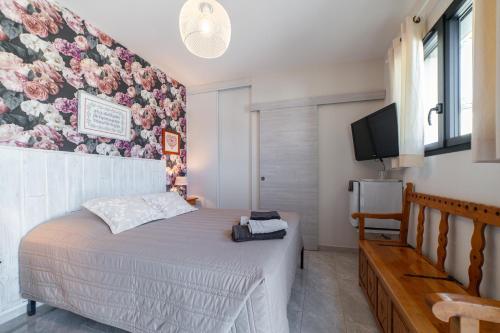 a bedroom with a bed with a floral wall at Chambre indépendante climatisée in Laroque-des-Albères