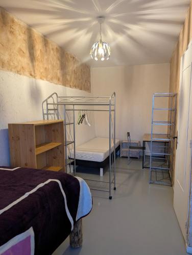 a bedroom with two bunk beds and a table at Gîte chez mémé in Assieu