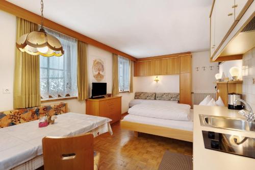a small room with two beds and a kitchen at Untersinnerhof Gsies in Valle Di Casies